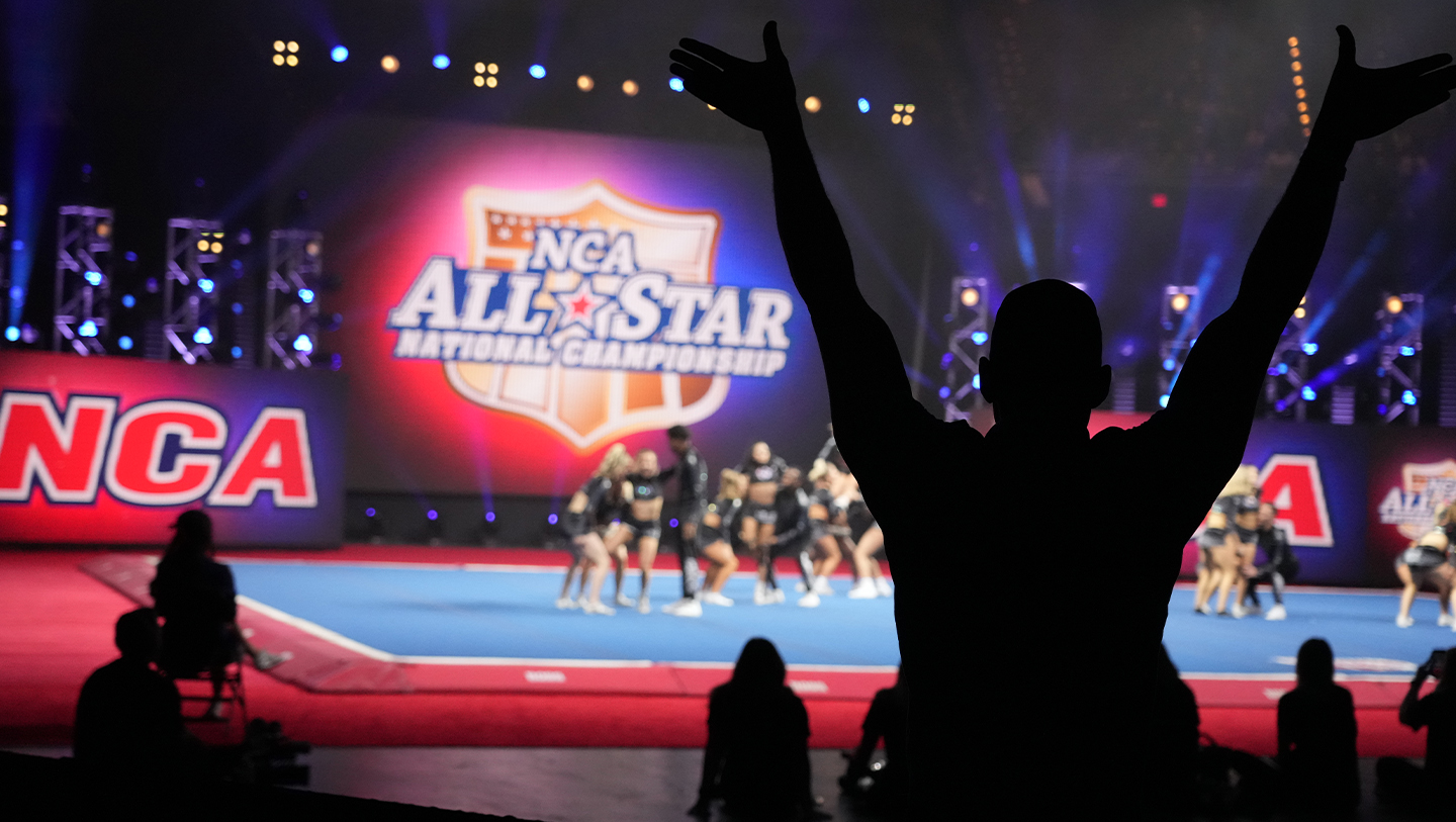 Coach cheering for team performing at NCA All Star Nationals